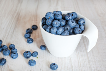 White bowl cup with fresh ripe blueberries