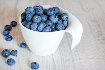 White bowl cup with fresh ripe blueberries