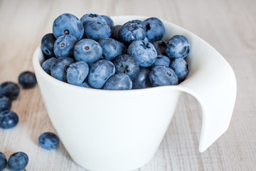 White bowl cup with fresh ripe blueberries
