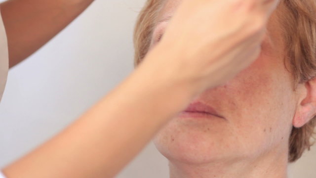 Esthetician - Closeup woman having applied makeup by makeup arti