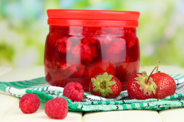 Home made berry jam on wooden table on bright background