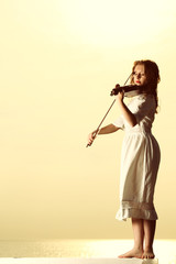 The blonde girl with a violin outdoor