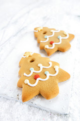 Gingerbread tree cookies on white wood and  snow background