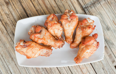 Fried chicken in a dish on bamboo flooring.