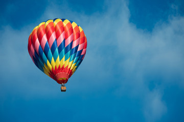 Brightly colored hot air balloon with a sky blue background