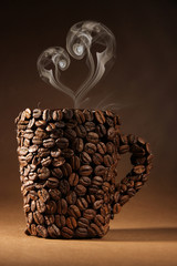 Cup of coffee beans with smoke in shape of heart