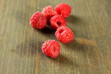 Ripe sweet raspberries on wooden background
