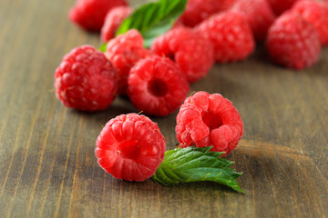 Ripe sweet raspberries on wooden background