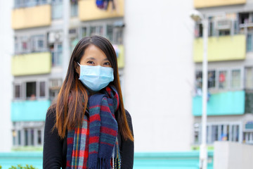 Woman wearing medical face mask in crowded city
