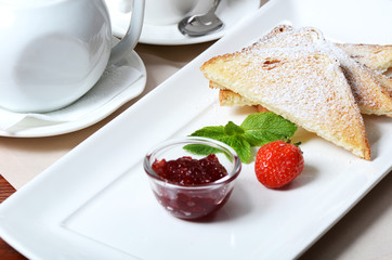 Toasts with powdered sugar and strawberry jam