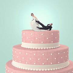  funny image of a married couple on a wedding cake. the groom tries to escape but the bride catches...