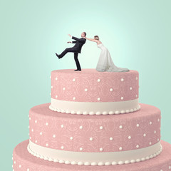  funny image of a married couple on a wedding cake. the groom tries to escape but the bride catches him.
