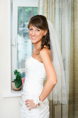 beautiful happy bride in a white dress looking at camera