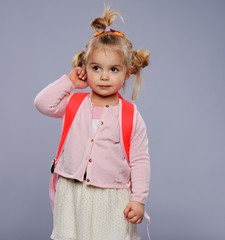 Funny little school girl with a backpack 