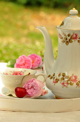 Gedeck auf Tablett mit Rosen und Kirsche