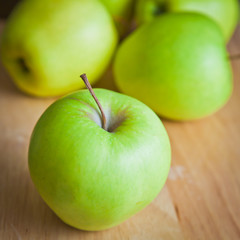 Green apples on a wooden board