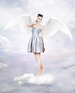 Beautiful brunette woman as angel in heaven