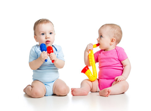 Babies girl and boy  playing musical toys. Isolated on white bac
