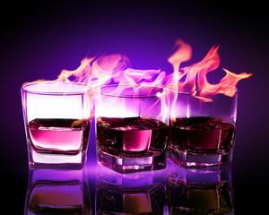 Three glasses of burning purple absinthe