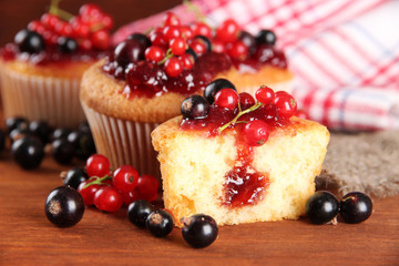 Tasty muffins with berries on wooden table