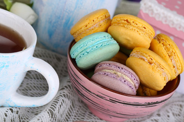 Macaroons in bowl on wooden table close-up