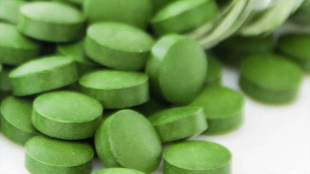 Medical pills placed on rotating table, shot with white seamless
