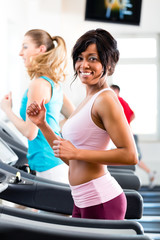 Fototapeta na wymiar People in sport gym on treadmill running