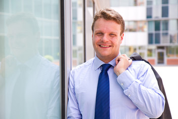 Smiling businessman standing outside a building