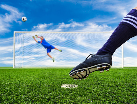 foot shooting soccer ball out of goal