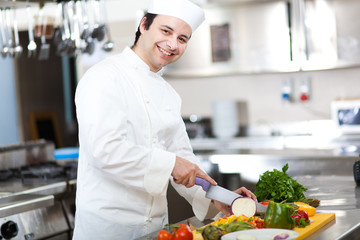 Friendly chef preparing vegetables in his kitchen
