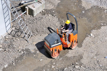 Chantier : ouvrier en action sur son rouleau compresseur