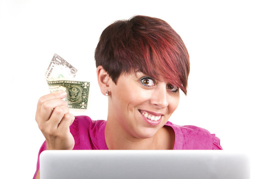 Smiling business woman using laptop with money