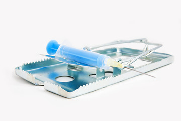 Addiction concept image of risks - mouse trap with blue syringe