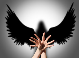 Angel, hand shadow like wings of darkness