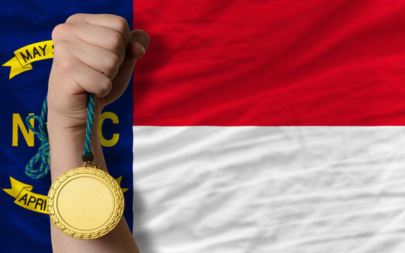 Gold medal for sport and flag of american state of north caroli
