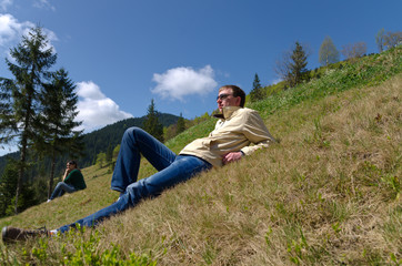 Naklejka na ściany i meble Man relaxing on a steep slope