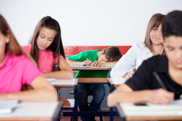 Male Student Sleeping On At Classroom