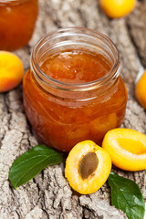 Apricot jam on wooden background