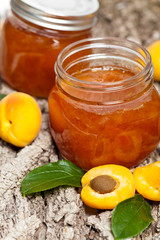 Apricot jam on wooden background