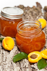 Apricot jam on wooden background