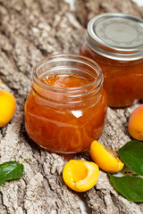Apricot jam on wooden background