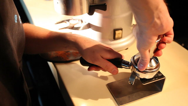 View of bartender compresses ground coffee