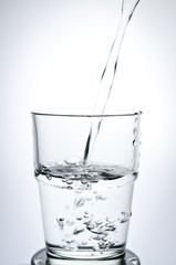 Filling a glass with water showing a drink concept
