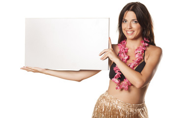 smiling girl in a straw skirt holding a blank advertising banner