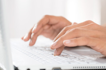 Close up of male hands typing on a laptop
