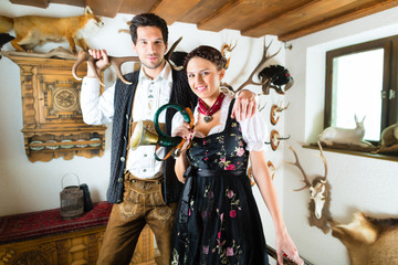 Jäger und Frau in einer Jagdhütte in den Alpen - obrazy, fototapety, plakaty