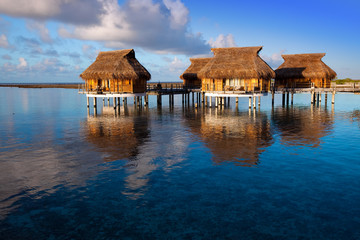 houses over the transparent quiet sea water  on a sunset
