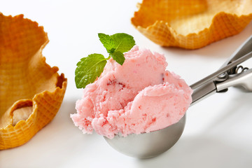 Scoop of strawberry ice cream and waffle baskets