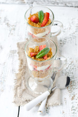 Dessert from sponge cake , strawberries and cream in a glass