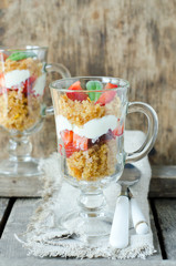 Dessert from sponge cake , strawberries and cream in a glass